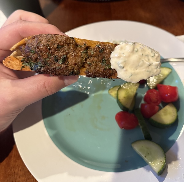 Arayes with a yogurt dipping sauce and a tomato and cucumber salad